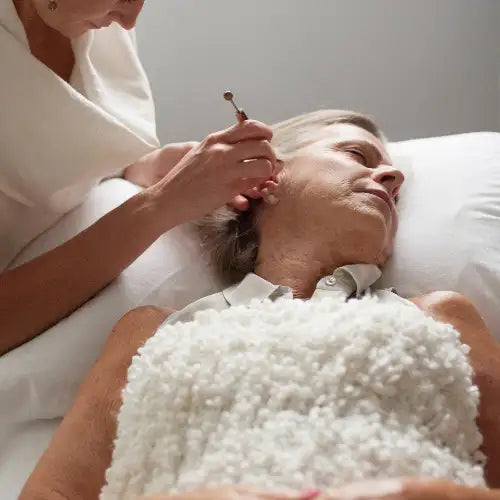 Gold ear pick with a textured handle, likely made of metal.