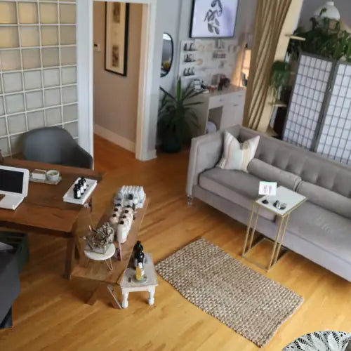 Gray sofa with white cushions and wooden legs, modern design.