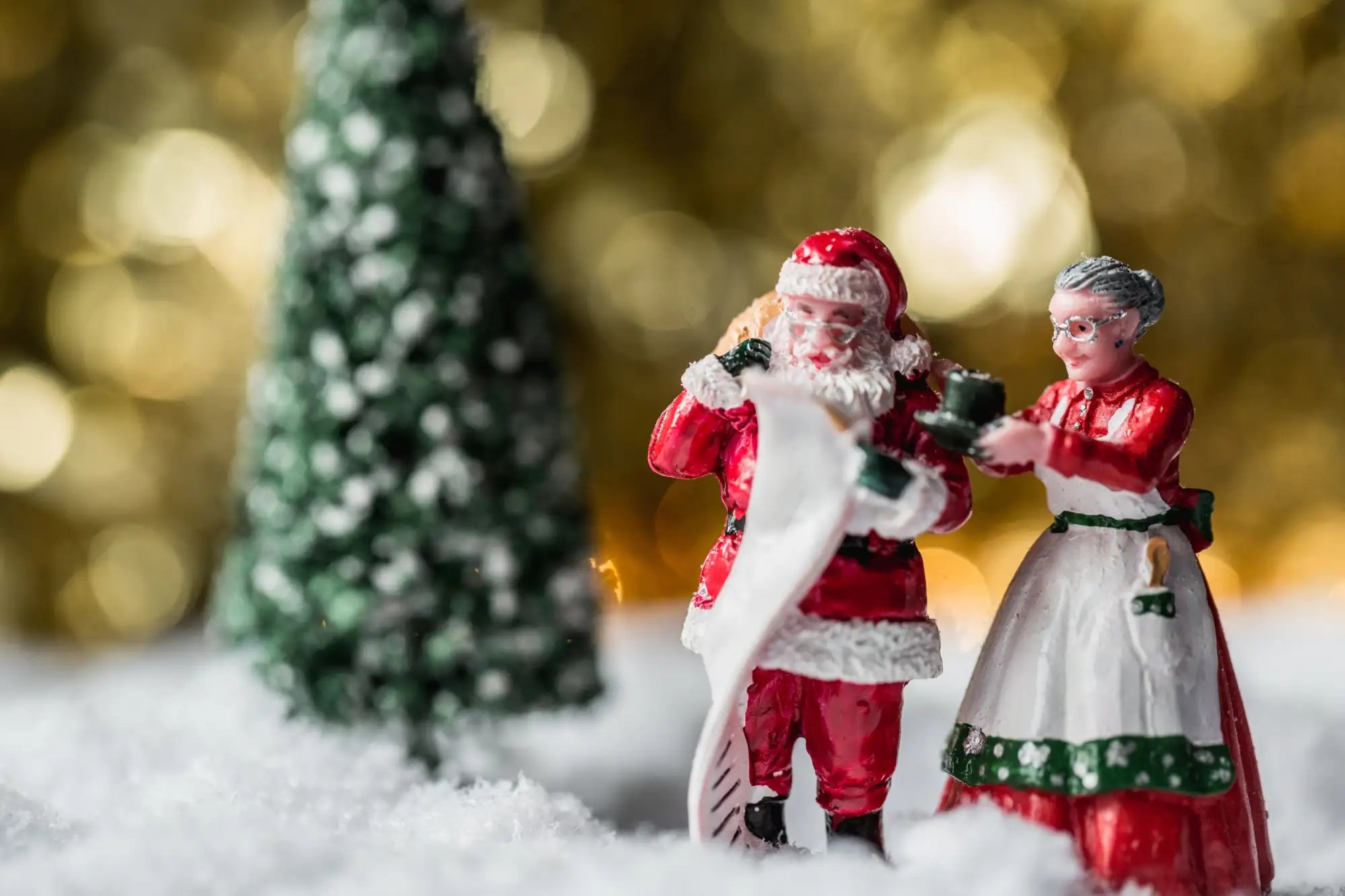 Red and white santa claus figurine with a fluffy beard, wearing traditional festive attire.