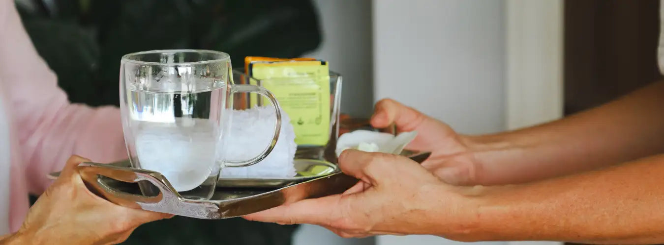 Silver tray with glass mug and ice cubes, clear glassware, stainless steel material.