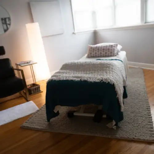 White and teal woven rug with fringe details.