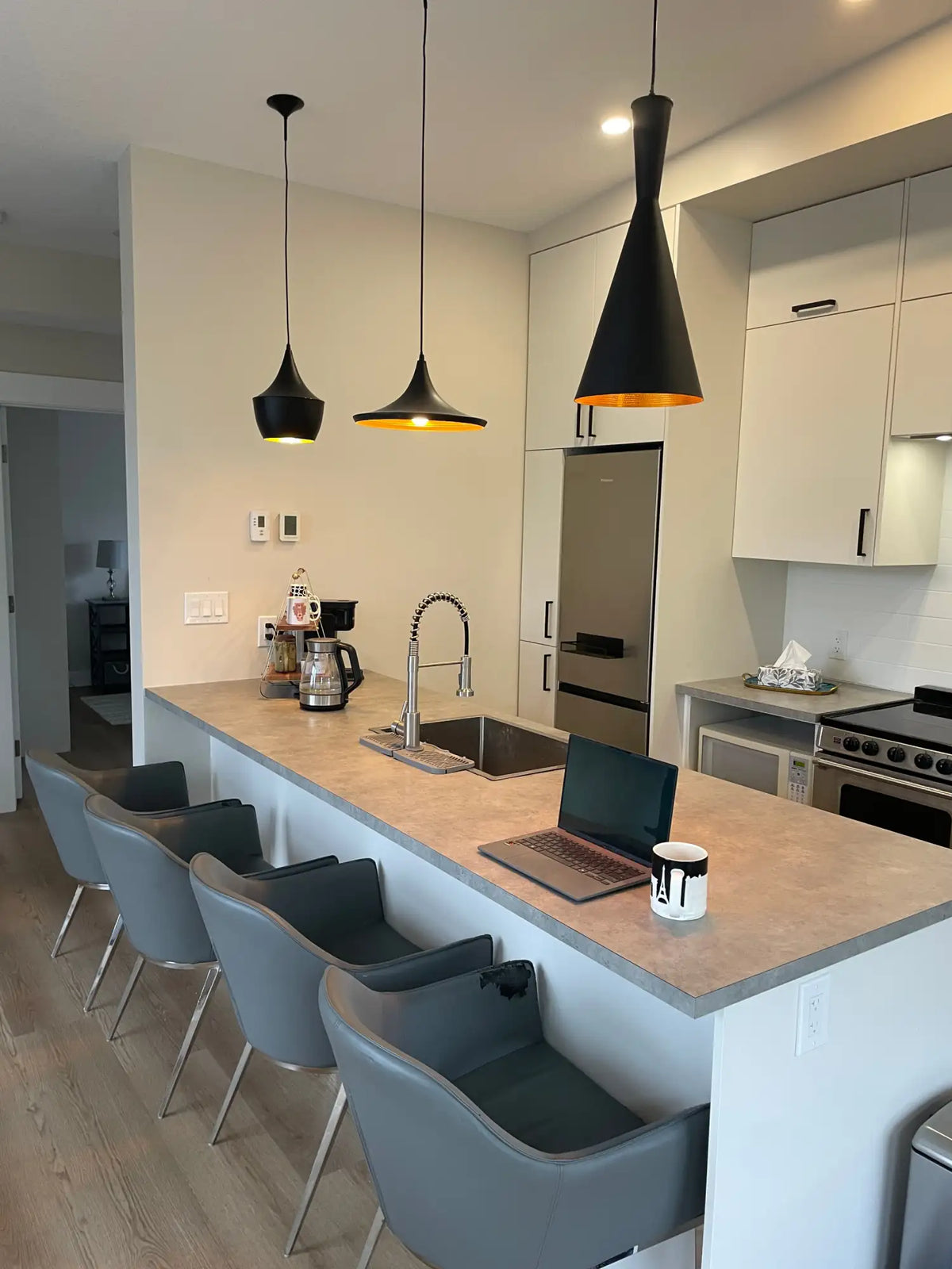 Black conical pendant lights with gold interior accents hanging above a kitchen island