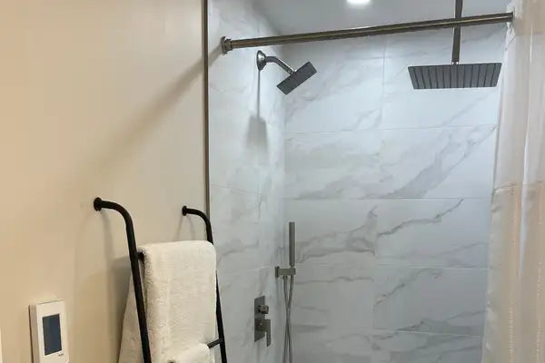 Modern black showerhead with a sleek, rectangular design mounted on a chrome-finished rail.