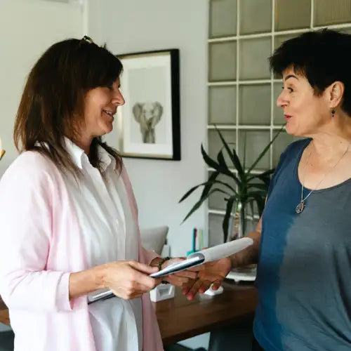 Pink and white button-down shirt with long sleeves, light blue jeans, black leather belt with silver buckle.